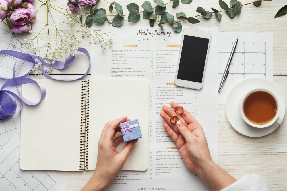 Flat lay with wedding planning checklist, rings, and notebook to choose budget friendly wedding venues wisely.