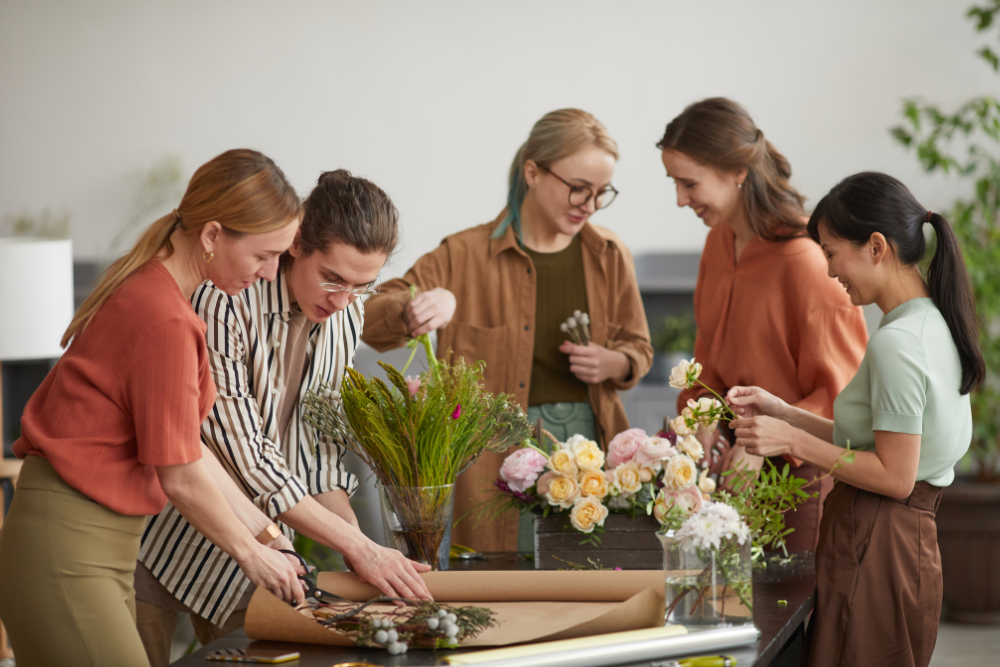 Event décor team arranging flowers as part of an indoor venue setup, showing what does all inclusive mean for couples planning a celebration.